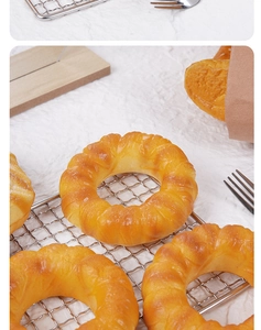 Macro shot of realistic PU donut toy showing detailed golden texture on metal cooling rack