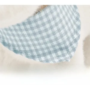 Detail of blue plaid collar with reinforced stitching on white plush plushie dog toy
