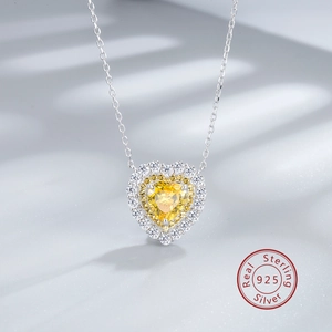 Detail of a 925 sterling silver necklace featuring a heart-shaped yellow gemstone pendant