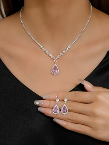 Macro view of water drop pendant necklace and earrings with pink zircon stones