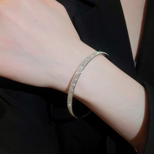 Close-up of elegant silver-toned thin bracelet with sparkling pavé-set stones on wrist