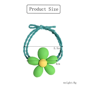 Detail view of a 5.5cm green flower hair tie with size annotations and weight information