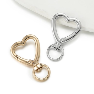 Detail of heart-shaped lobster clasps in gold and silver finish with swivel rings