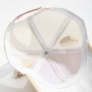 Detail view of breathable mesh lining and adjustable strap on a beige kids' baseball cap