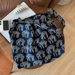 Large navy canvas tote bag featuring white sheep print on a rustic wooden table setup