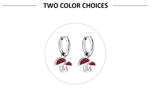 Close-up of silver mushroom charm earrings with deep red enamel finish and hoop design
