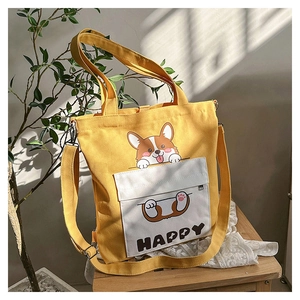 Detail of yellow canvas tote bag featuring a cute corgi print and adjustable shoulder strap