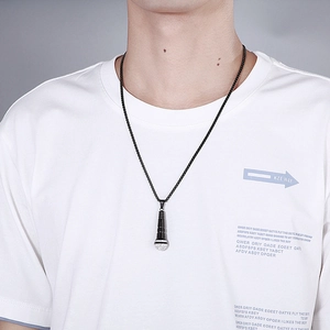 Close-up of black microphone pendant with diamond details on a sleek chain for men