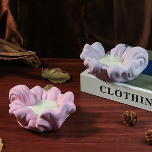 Detail shot of wavy petal-shaped aromatherapy candles in soft pink and purple tones