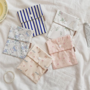 Flat lay of small floral fabric pouches with snap closures on white textured cloth