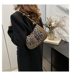 Close-up of leopard print shoulder bag with adjustable strap and metal buckle details