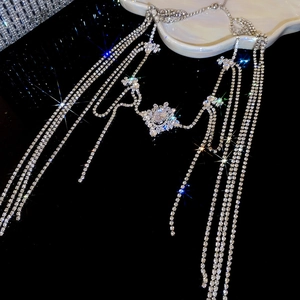 Macro view of silver fringe body chain with sparkling zircon starburst pendant