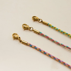 Close-up of colorful woven cotton bracelets with gold-plated metal clasp and end caps