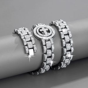 Detailed view of silver iced-out hip-hop bracelet set with rotating cross motif on a stand