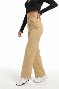 Détail du pantalon large taille haute kaki montrant la texture du tissu et les coutures