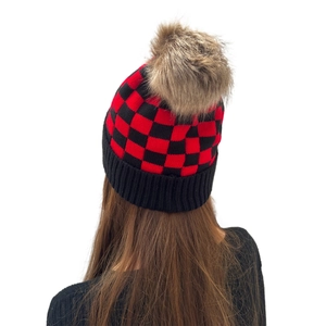 Adult winter knit beanie with red and black checkerboard pattern and brown faux fur pom-pom