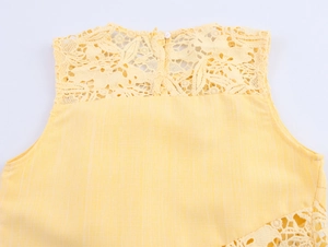 Close-up of yellow sleeveless top featuring delicate lace patchwork and floral cutouts