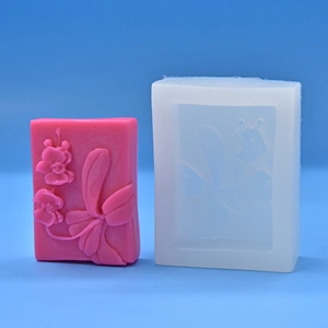 Orchid embossed silicone mold and pink floral soap set on blue background