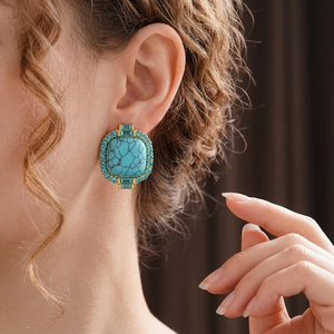 Vintage gold-toned square earrings with turquoise stone and blue crystal halo on model