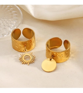 Detail of 18K gold plated hammered texture open rings with sun and disk charms