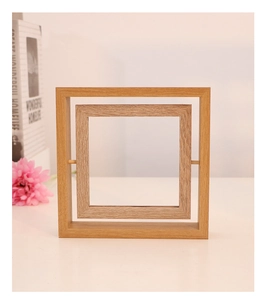 Detailed view of rotating wooden photo frame with natural grain on a white desktop