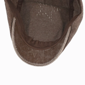 Détail intérieur d'une casquette marron vintage avec une étoile cousue sur la visière