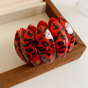 Detailed view of leopard print resin bangle on a brown velvet jewelry display tray