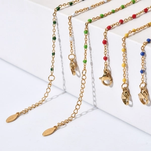 Detail of colorful enamel bead bracelets with S.STEEL tags on a gold-plated chain