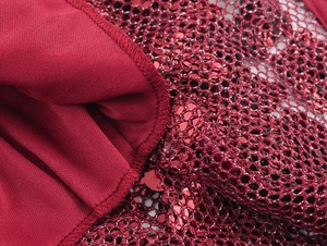 Macro detail of red sequin stitching and smooth knit fabric on a sexy party dress