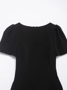 Detail view of black off-shoulder dress featuring puff sleeves and back zipper closure