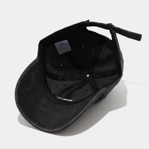 Detail view of washed cotton baseball cap showing adjustable metal buckle and sweatband