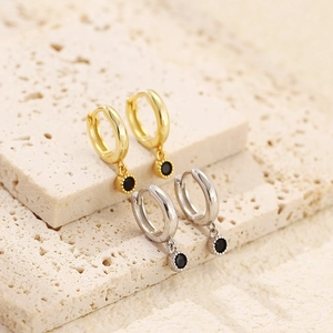 Detail of gold and silver S925 sterling silver hoop earrings with black zircon pendants