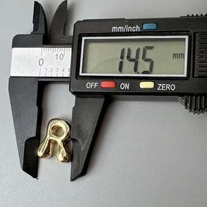 Detailed measurement of gold letter R pendant showing 14.5mm size on digital caliper