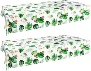 Detail of tropical palm leaves and plumeria print on a white PEVA Hawaiian party tablecloth