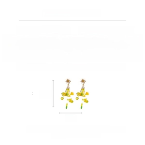 Détail de longues boucles d'oreilles à fleurs jaunes avec zircons et perles