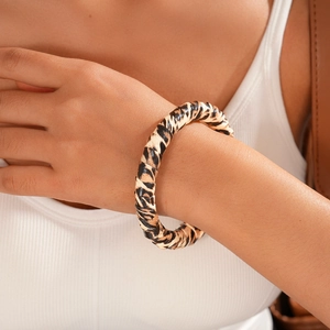 Close-up of leopard print acrylic round bangle bracelet worn by model on wrist