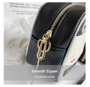Detail showing smooth gold metal zipper and cartoon lip embroidery on the bag