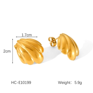 Detail of gold shell earrings showing dimensions 2cm by 1.7cm and polished metal texture