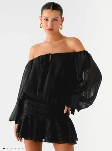 Gros plan sur la robe noire à épaules dénudées avec volants superposés et mousseline gaufrée