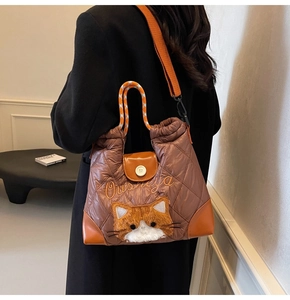 Brown quilted tote bag with orange woven handles and cute plush cat embroidery