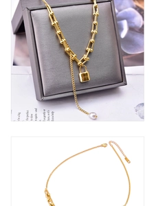Detail of gold U-link chain necklace featuring LOVE lock pendant and white pearl charm