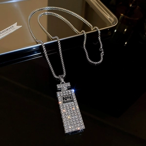 Detailed macro view of silver perfume bottle pendant with rhinestones and engraving