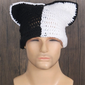 Close-up of black and white cat ear knit beanie showing thick crochet texture and seams