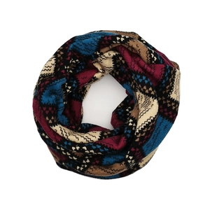 Detail of vintage geometric knit infinity scarf with blue and burgundy pattern texture