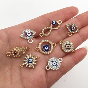 Detailed view of assorted Evil Eye charm pendants with blue enamel and crystal accents