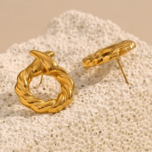 Gros plan de boucles d'oreilles créoles torsadées plaquées or 18K avec détail en X