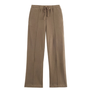 Detail of dark brown knit trousers with drawstring elastic waist and center seam line