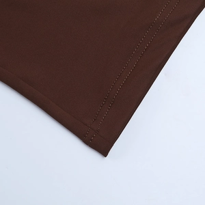 Detailed close-up of double-stitched hem on a dark brown long-sleeved evening dress