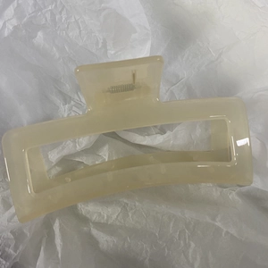Macro view of extra-large cream translucent rectangular claw clip for thick hair