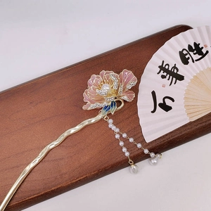 Macro view of golden peony hair pin with pink enamel petals and pearl tassel details